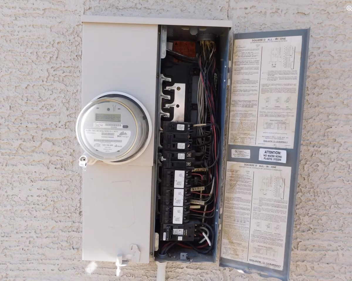 Electrical meter and service panel opened during an inspection